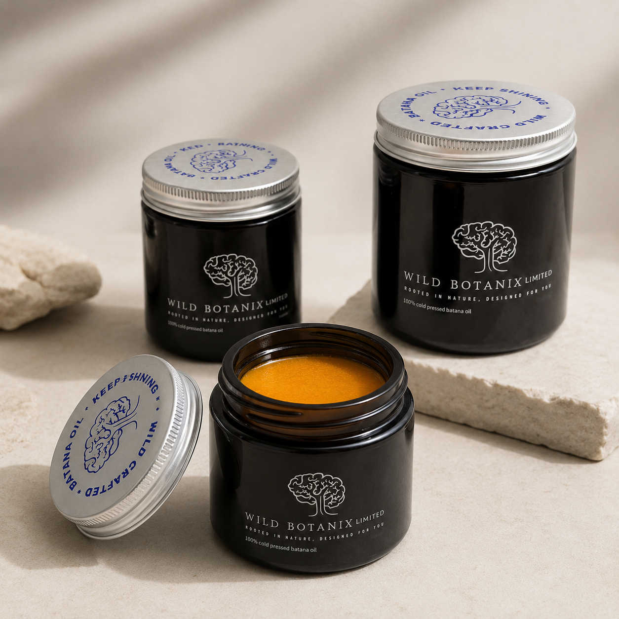 Wild Botanix Cold-Pressed Batana Oil open jar lifestyle image showing the natural orange-gold oil texture